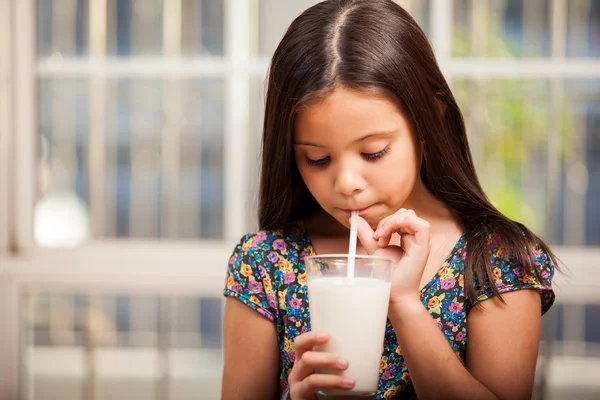 Beautiful little girl drinking milk with tubule — Stock Photo, Image