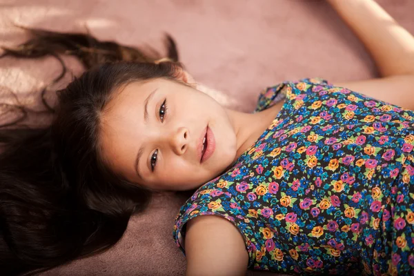 Niña acostada en la alfombra — Foto de Stock