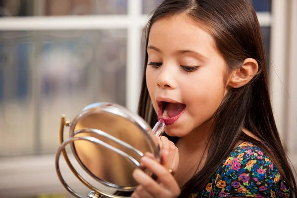 Little girl trying painting her lips — Stock Photo, Image