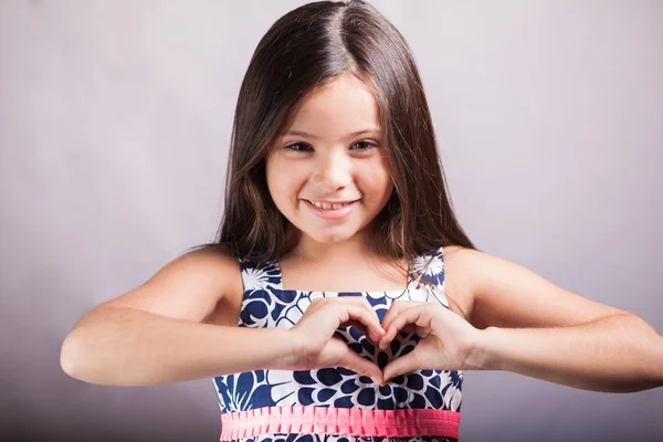 Menina faz um gesto na forma do coração . — Fotografia de Stock