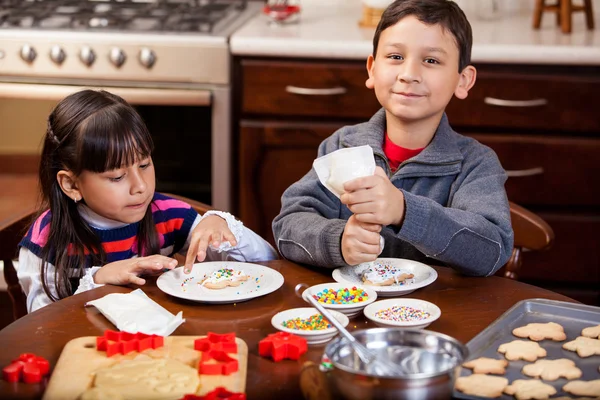 Boy and his sister decorating some Christmas cookies — Stock Photo, Image
