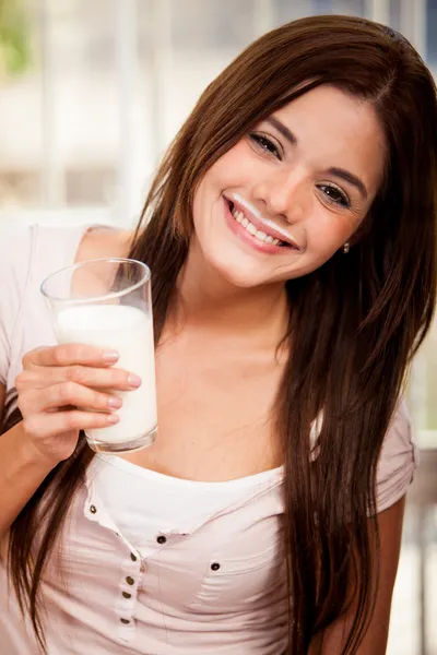 Leende flicka håller glas mjölk — Stockfoto