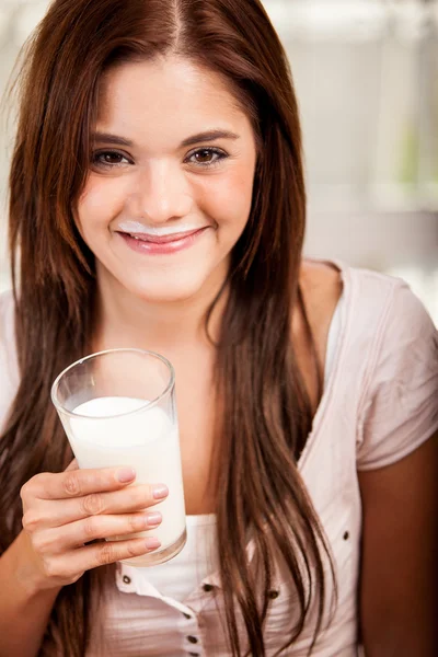 Uśmiechnięta dziewczynka trzymając szklankę mleka — Zdjęcie stockowe