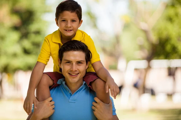 Son sitting on father shoulders — Stock Photo, Image