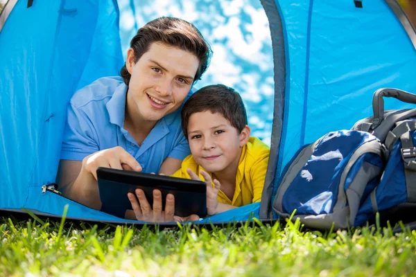 Father with his son using tablet in their tent — Stock Photo, Image