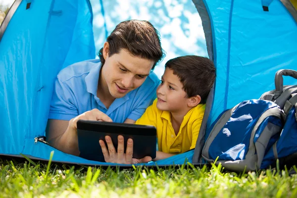 Ojciec z synem za pomocą tabletu w swoim namiocie — Zdjęcie stockowe