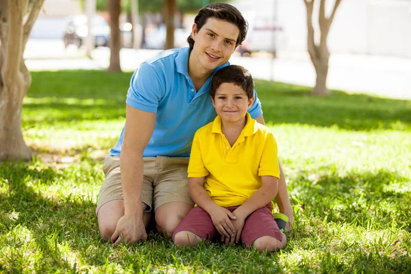 Padre e figlio sono seduti sull'erba — Foto Stock