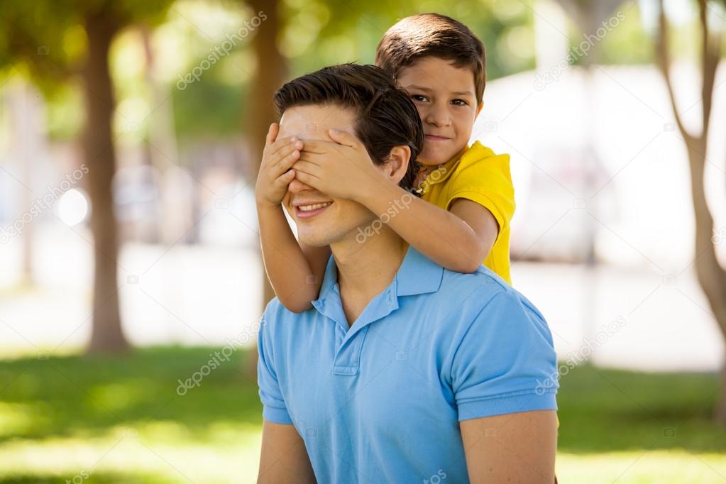 Father giving son piggyback ride with closed eyes