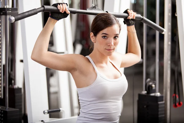 Girl shakes muscle simulator — Stock Photo, Image