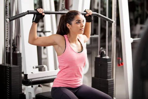 Girl shakes muscle simulator — Stock Photo, Image