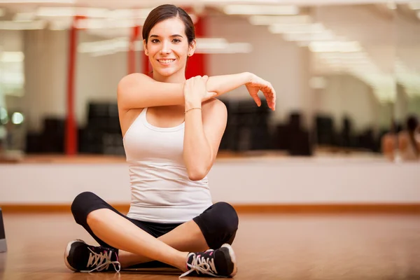 La chica se dedica a la gimnasia en una sala de deportes —  Fotos de Stock