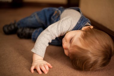 bir yerde yatarken erkek bebek