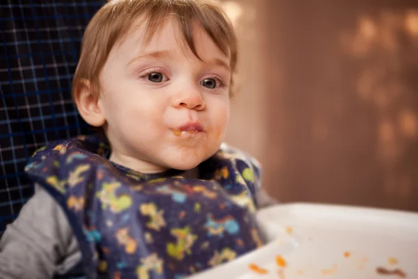 Baby girl eating in highchair — Stock Photo, Image