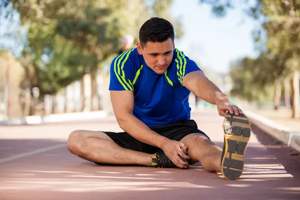 Ung idrottsman stretching — Stockfoto