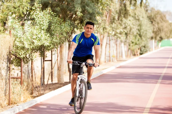 Genç latin erkek bir Bisiklete binmek — Stok fotoğraf