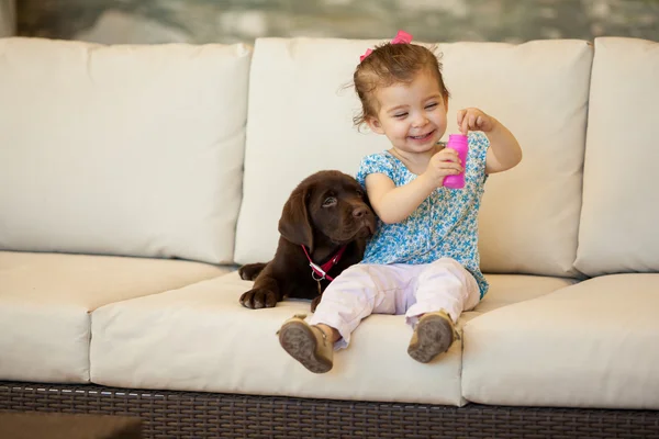 Tjej med en hund och såpbubblor — Stockfoto