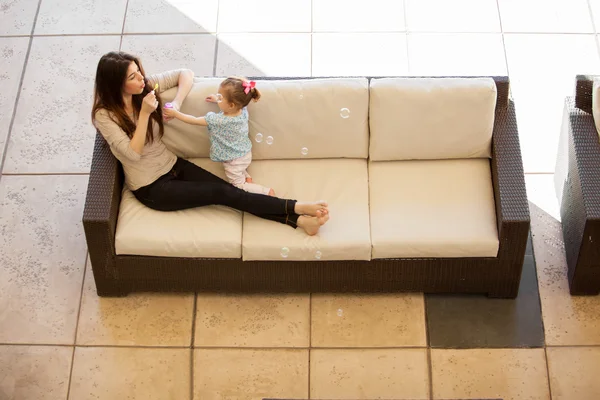 Madre e figlia gioca sul divano — Foto Stock