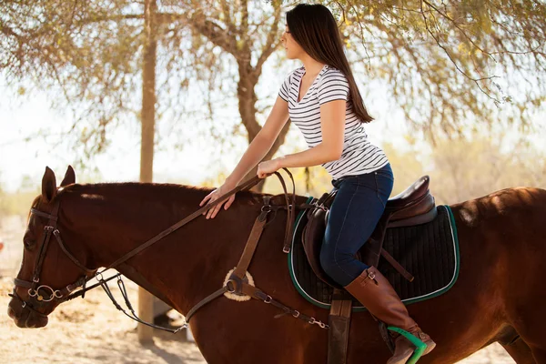 Kvinna som rider en häst på en solig dag — Stockfoto