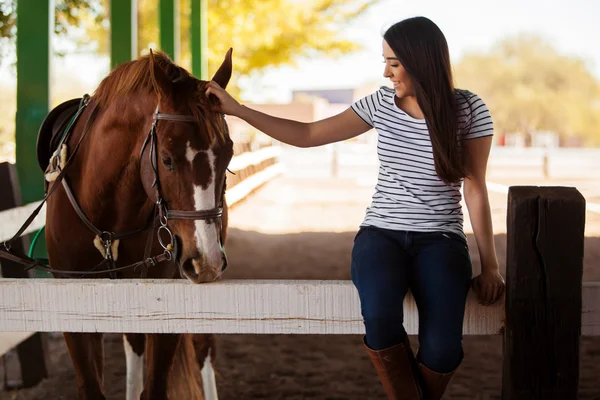 Kvinna petting och ha kul med en häst i en ranch — Stockfoto