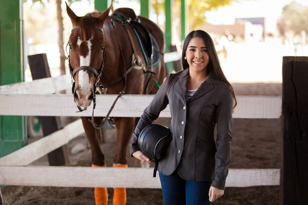 Jockey femenino posando junto a su caballo — Foto de Stock