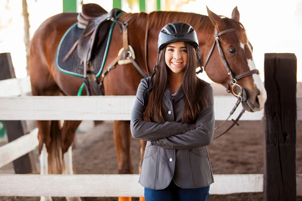 Jockey femenino de pie junto a un caballo — Foto de Stock