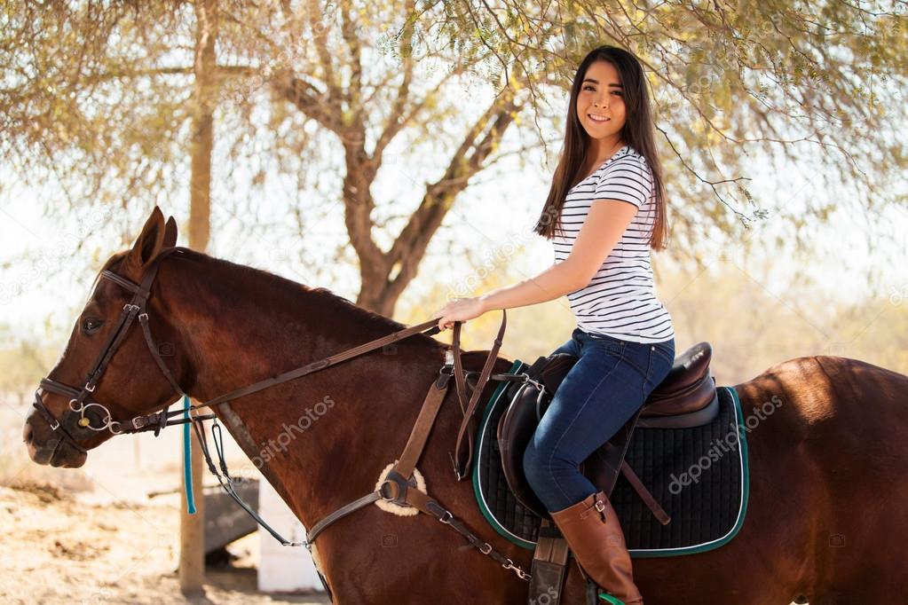 Brunette riding her horse on a sunny day