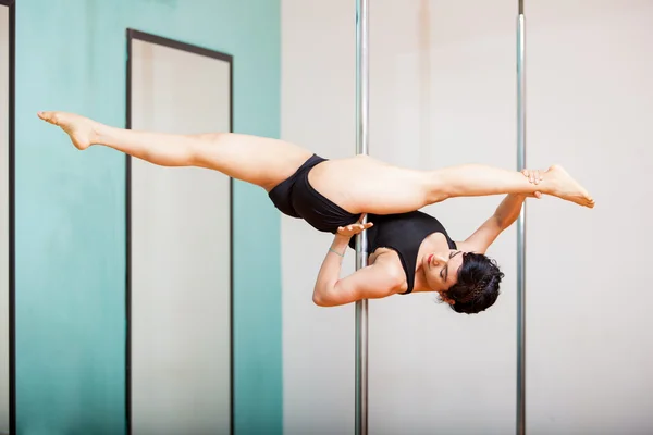 Vrouw met een pose in een pole fitness klasse — Stockfoto