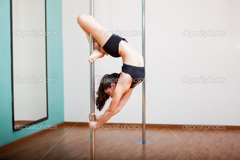 Woman holding a pose in a pole fitness class