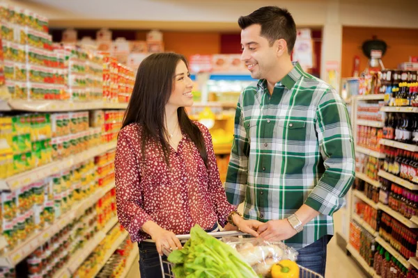 Young couple looking to each other at the store — Stock Photo, Image