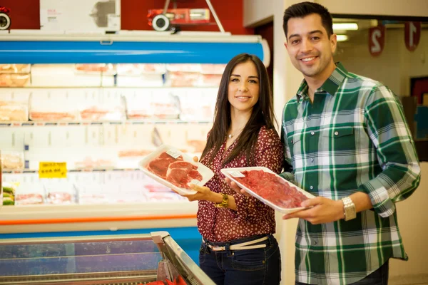 Милая молодая пара покупает мясо — стоковое фото