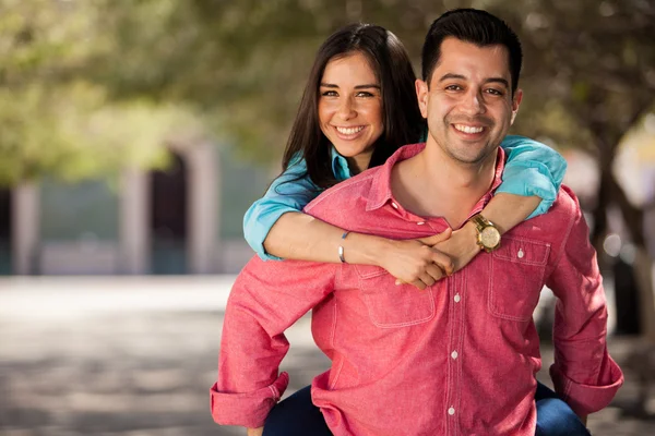 Young happy woman riding on the back of her boyfriend — Stock Photo, Image