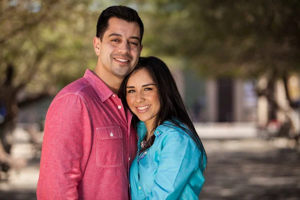 Cute girl and her boyfriend smiling while standing in the park — Stock Photo, Image