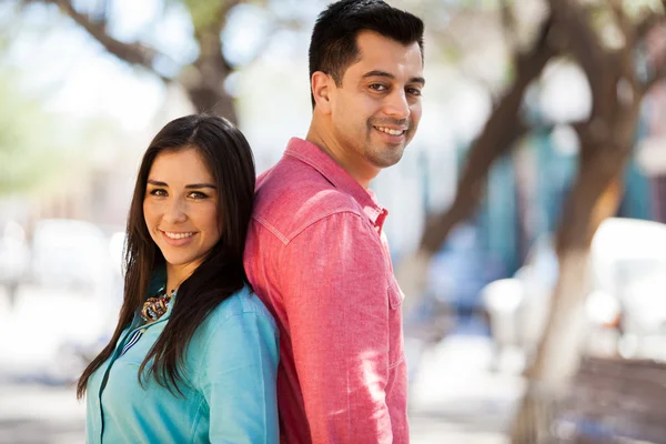 Lyckliga par stå rygg mot rygg utomhus — Stockfoto