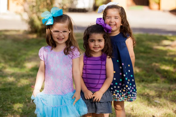 Drie kleine zusters opknoping uit bij een park en glimlachen — Stockfoto