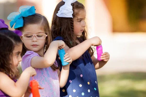 Lindas niñas compitiendo para ver quién hace más burbujas —  Fotos de Stock