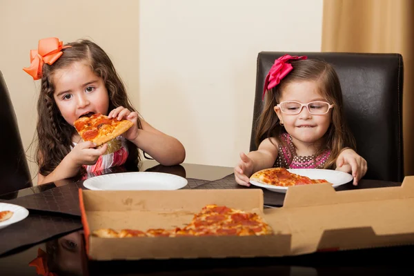 Lindas meninas hispânicas comendo pizza juntas em casa — Fotografia de Stock