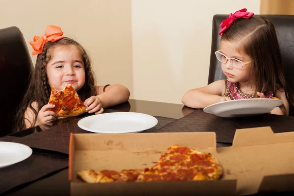 Mooie broers en zussen met plezier en enkele pizza eten thuis — Stockfoto