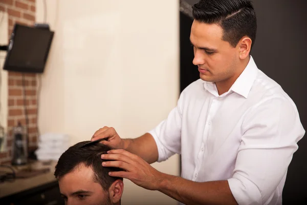 Jeune coiffeur coupe les cheveux — Photo