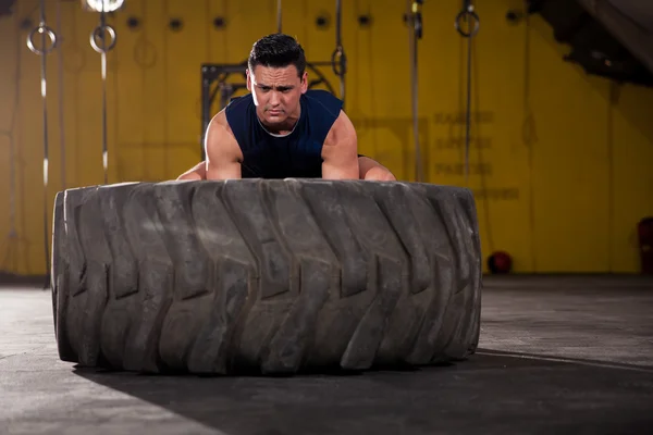 Determined to lift up a tire — Stock Photo, Image