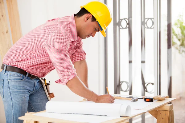 Bonito engenheiro hispânico fazendo algum trabalho de design e remodelando uma casa — Fotografia de Stock