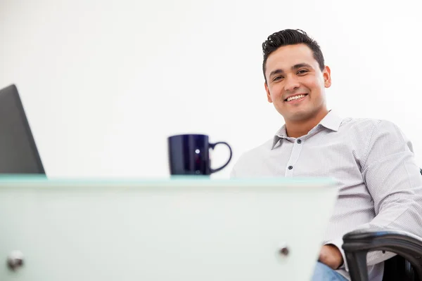 Retrato de un joven latino trabajando en su oficina y tomando café —  Fotos de Stock