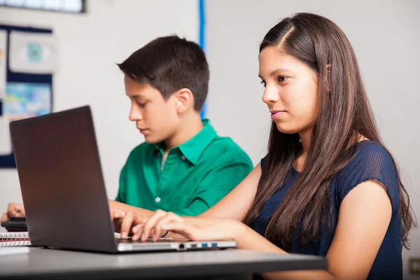 Cute brunette using a laptop — Stock Photo, Image