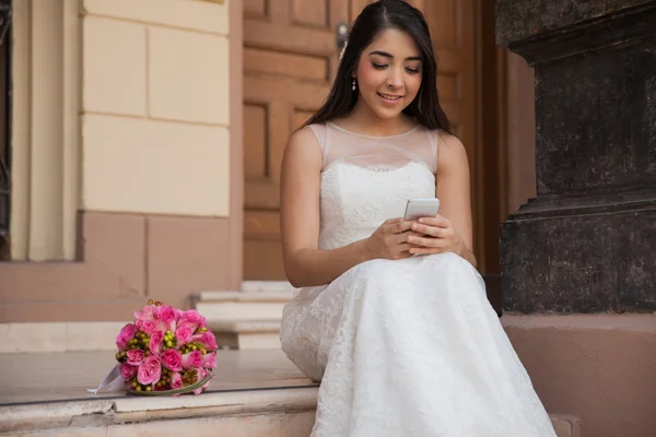 Bride texting with cell phone on wedding — Stock Photo, Image