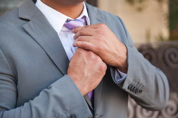 Young man fixing his tie