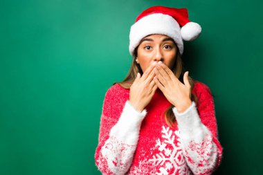 Vay canına! Çekici genç kadın şaşırmış görünüyor ve ağzını kapatırken çığlık atmamaya çalışıyor. 