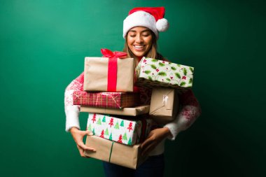 Hediyelerimizi vermeye hazırız. Çekici bir kadının portresi bir sürü Noel hediyesi taşıyor. 