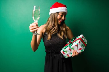 Çekici bir kadın kadeh kaldırıyor ve Noel partisindeki hediyeler için konuğuna teşekkür ediyor.