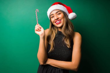 Çubuk şekere bayılırım. Güzel İspanyol kadın Noel arifesinde baston şeker tutuyor.