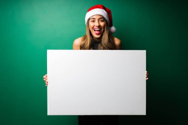 Sürpriz! Heyecanlı genç bir kadın Noel için mükemmel bir satış teklifiyle boş bir tabela gösteriyor.