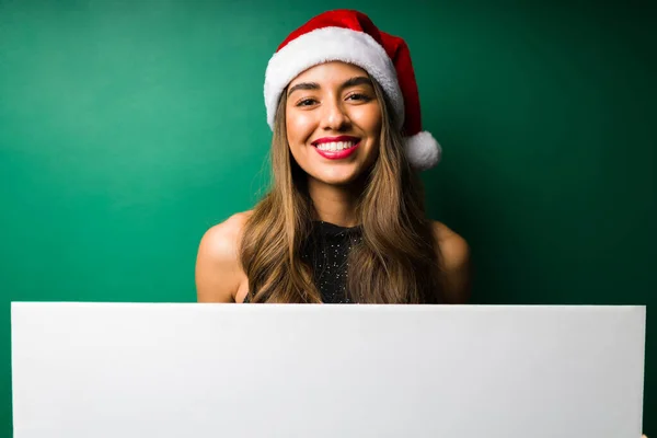 在一个漂亮的年轻女子身边 她拿着一个大大的空白圣诞标志 开心极了 — 图库照片